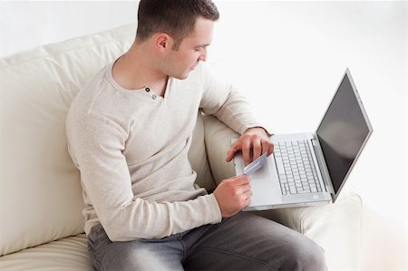 face to internet technology - Man purchasing online in his living room Photographie de stock - Aubaine LD & Abonnement, Code: 400-05715686