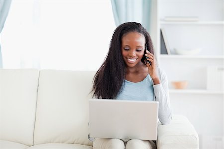 simsearch:400-05716447,k - Smiling woman with laptop and smartphone on the sofa Stock Photo - Budget Royalty-Free & Subscription, Code: 400-05716430