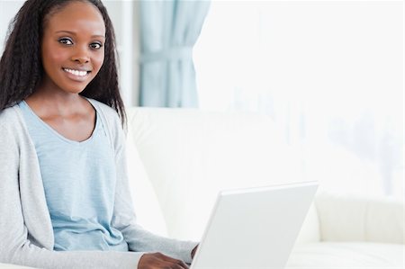 simsearch:400-05716451,k - Smiling young woman on sofa with notebook Stock Photo - Budget Royalty-Free & Subscription, Code: 400-05717077