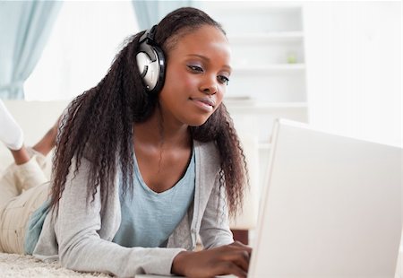 simsearch:400-05717206,k - Close up of young woman lying on the floor with her notebook enjoying music Stock Photo - Budget Royalty-Free & Subscription, Code: 400-05717191