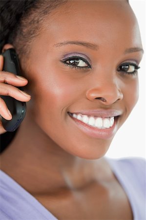 simsearch:400-05717423,k - Close up of smiling woman talking on the mobile phone against a white background Stock Photo - Budget Royalty-Free & Subscription, Code: 400-05717427