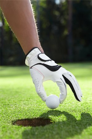 simsearch:400-05753062,k - Hand in glove puts the golf ball on the field Stock Photo - Budget Royalty-Free & Subscription, Code: 400-05717909