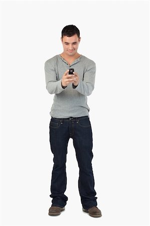 simsearch:400-06632132,k - Young male reading text message against a white background Stock Photo - Budget Royalty-Free & Subscription, Code: 400-05718559