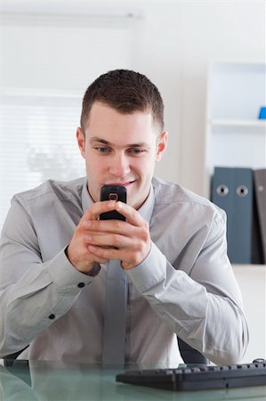 simsearch:400-05710264,k - Smiling businessman getting a pleasant text message Stock Photo - Budget Royalty-Free & Subscription, Code: 400-05710256