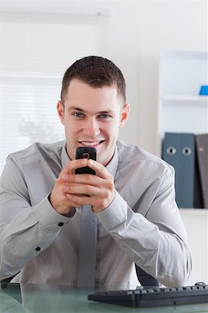 simsearch:400-05710264,k - Smiling businessman getting a pleasant text message on his cellphone Stock Photo - Budget Royalty-Free & Subscription, Code: 400-05710258