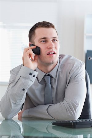 simsearch:400-05710264,k - Young businessman looking at the screen while listening to the caller Stock Photo - Budget Royalty-Free & Subscription, Code: 400-05710252