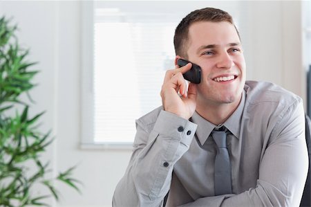 simsearch:400-05710264,k - Smiling businessman getting a pleasant call on his mobile phone Stock Photo - Budget Royalty-Free & Subscription, Code: 400-05710253