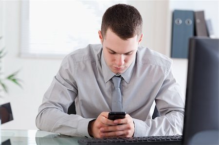 simsearch:400-05710264,k - Young businessman writing a textmessage Stock Photo - Budget Royalty-Free & Subscription, Code: 400-05710271