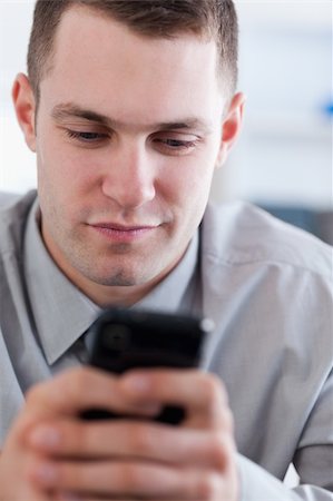 simsearch:400-05710264,k - Close up of young businessman reading text message on his cellphone Stock Photo - Budget Royalty-Free & Subscription, Code: 400-05710280