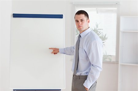 simsearch:400-05710386,k - Businessman pointing at something important at flip chart Stock Photo - Budget Royalty-Free & Subscription, Code: 400-05710355