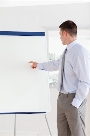 simsearch:400-05710386,k - Confident businessman pointing at the middle of a flip chart Stock Photo - Budget Royalty-Free & Subscription, Code: 400-05710359