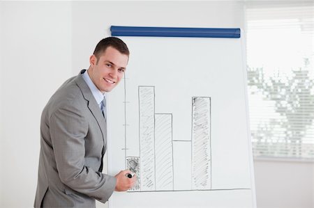 simsearch:400-05710386,k - Smiling young businessman editing column graph Stock Photo - Budget Royalty-Free & Subscription, Code: 400-05710385