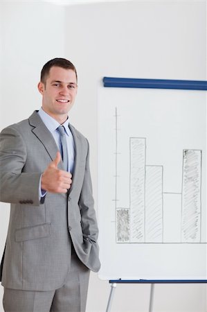 simsearch:400-05710386,k - Smiling businessman giving thumb up next to column graph Stock Photo - Budget Royalty-Free & Subscription, Code: 400-05710383