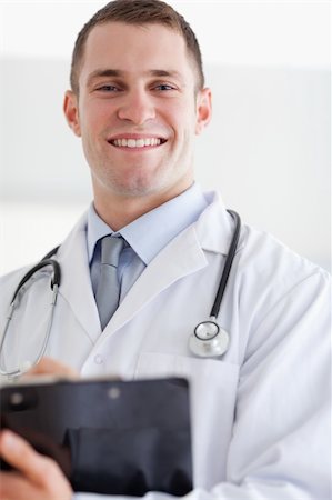 simsearch:400-05710403,k - Close up of smiling doctor with his notes Stock Photo - Budget Royalty-Free & Subscription, Code: 400-05710400