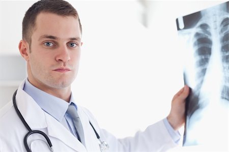 simsearch:400-05710403,k - Serious looking doctor showing x-ray image to patient Stock Photo - Budget Royalty-Free & Subscription, Code: 400-05710446