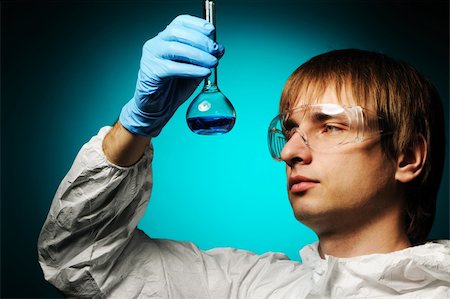 simsearch:400-04340735,k - Scientist in protective wear and glasses looking at chemical flask Stock Photo - Budget Royalty-Free & Subscription, Code: 400-05711624