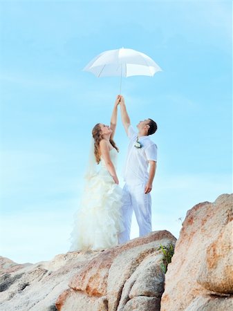 simsearch:400-05328142,k - Bride and groom holding an umbrella on a rock. Stock Photo - Budget Royalty-Free & Subscription, Code: 400-05712708