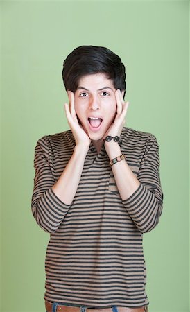 simsearch:400-05388090,k - Shocked Latino teen with hands on head over green background Stock Photo - Budget Royalty-Free & Subscription, Code: 400-05713941