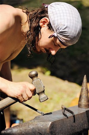 simsearch:400-06560568,k - Young blacksmith hammering hot iron on anvil Photographie de stock - Aubaine LD & Abonnement, Code: 400-05726035