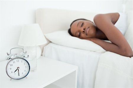 simsearch:400-05729462,k - Woman sleeping while her alarm clock is ringing in her bedroom Stock Photo - Budget Royalty-Free & Subscription, Code: 400-05729350