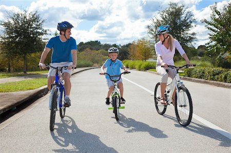 simsearch:400-05755734,k - A young family of man and woman parents and one boy child, cycling together. Photographie de stock - Aubaine LD & Abonnement, Code: 400-05721410