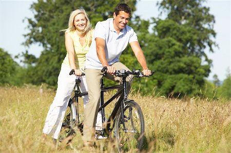 Couple riding tandem in countryside Stock Photo - Budget Royalty-Free & Subscription, Code: 400-05736041