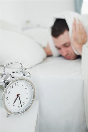 simsearch:6109-06194878,k - Portrait of an attractive man covering his ears while his alarm clock is ringing in his bedroom Stock Photo - Budget Royalty-Free & Subscription, Code: 400-05737284