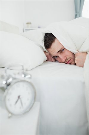 simsearch:6109-06194878,k - Portrait of a young man covering his ears while his alarm clock is ringing in his bedroom Stock Photo - Budget Royalty-Free & Subscription, Code: 400-05737281