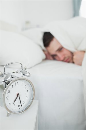 simsearch:6109-06194878,k - Portrait of a tired man covering his ears while his alarm clock is ringing in his bedroom Stock Photo - Budget Royalty-Free & Subscription, Code: 400-05737282