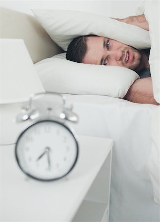 simsearch:6109-06194878,k - Portrait of a handsome young man covering his ears while his alarm clock is ringing in his bedroom Stock Photo - Budget Royalty-Free & Subscription, Code: 400-05737291