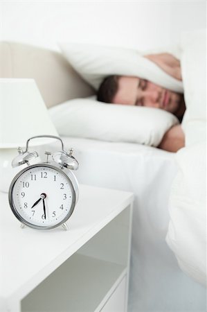 simsearch:6109-06194878,k - Portrait of a unhappy young man covering his ears with a pillow while his alarm clock is ringing Stock Photo - Budget Royalty-Free & Subscription, Code: 400-05737356