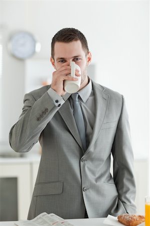 drinking coffee in paper cups - Portrait of a handsome businessman having breakfast in his kitchen Stock Photo - Budget Royalty-Free & Subscription, Code: 400-05737612