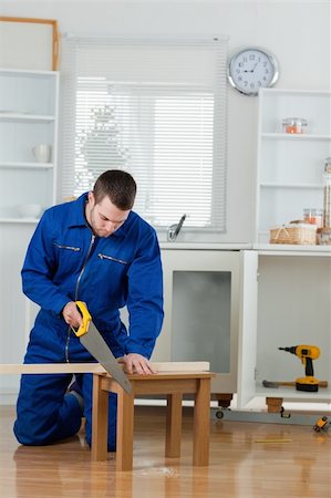 simsearch:700-02071118,k - Portrait of a handsome handyman cutting a wooden board in a kitchen Stock Photo - Budget Royalty-Free & Subscription, Code: 400-05737684