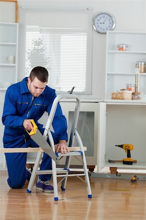 simsearch:700-02071118,k - Portrait of a young handyman cutting a wooden board in a kitchen Stock Photo - Budget Royalty-Free & Subscription, Code: 400-05737681