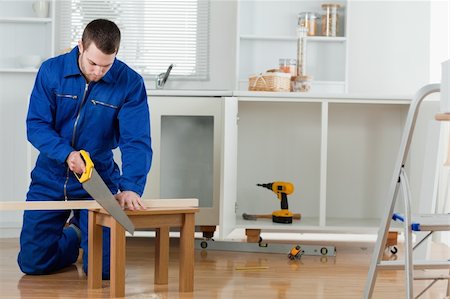 simsearch:700-02071118,k - Young handyman cutting a wooden board in a kitchen Stock Photo - Budget Royalty-Free & Subscription, Code: 400-05737682