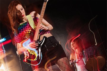 simsearch:400-04652753,k - Photo of a young beautiful woman playing guitar with drummer in the background.  Motion blur and light trails from slow shutter speed and strobes. Space for text. Stock Photo - Budget Royalty-Free & Subscription, Code: 400-05732100