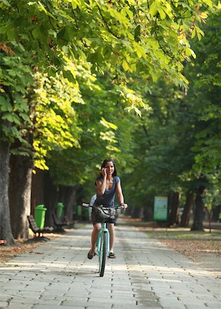 riding bike female basket - Image of a woman on the phone riding a bicyclein an autumn park Stock Photo - Budget Royalty-Free & Subscription, Code: 400-05732159