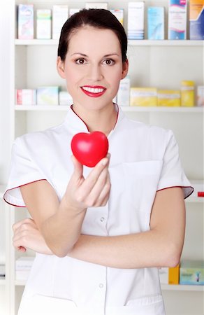 Pretty caucasian pharmacist holding red heart. Stock Photo - Budget Royalty-Free & Subscription, Code: 400-05745338