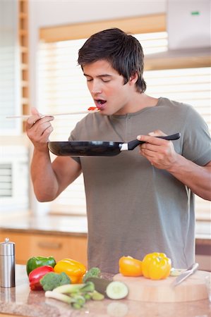 simsearch:400-05744780,k - Portrait of a man tasting his meal in his kitchen Stock Photo - Budget Royalty-Free & Subscription, Code: 400-05746861