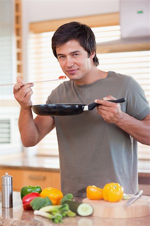 simsearch:400-05744780,k - Portrait of a handsome man tasting his meal in his kitchen Stock Photo - Budget Royalty-Free & Subscription, Code: 400-05746863