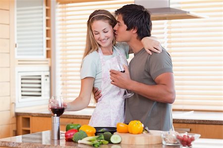 simsearch:400-05740111,k - Lovely couple drinking wine while kissing in their kitchen Stock Photo - Budget Royalty-Free & Subscription, Code: 400-05746876