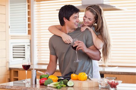 simsearch:400-05740111,k - Lovely couple drinking wine while hugging in their kitchen Stock Photo - Budget Royalty-Free & Subscription, Code: 400-05746877