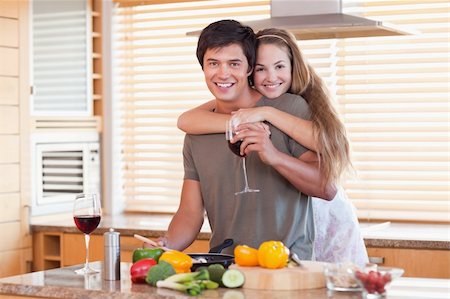 simsearch:400-05740111,k - Lovely couple drinking red wine while hugging in their kitchen Stock Photo - Budget Royalty-Free & Subscription, Code: 400-05746878