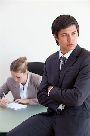 simsearch:400-05746962,k - Portrait of a manager posing while his colleague is working in an office Stock Photo - Budget Royalty-Free & Subscription, Code: 400-05746962