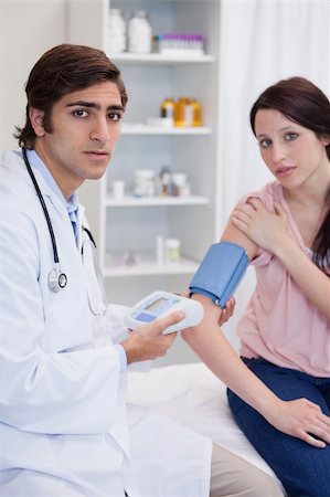 simsearch:400-05748252,k - Male doctor examining patients blood pressure Stock Photo - Budget Royalty-Free & Subscription, Code: 400-05747058