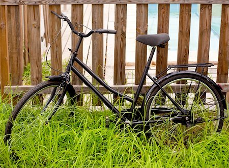 black grunge bicycle aged on a wood fence and grass Stock Photo - Budget Royalty-Free & Subscription, Code: 400-05747347