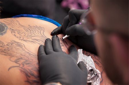 Tattoo expert draws outlined design on a woman's back Stock Photo - Budget Royalty-Free & Subscription, Code: 400-05747819