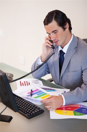 simsearch:400-05748170,k - Young businessman on the phone talking about statistics Stock Photo - Budget Royalty-Free & Subscription, Code: 400-05748142