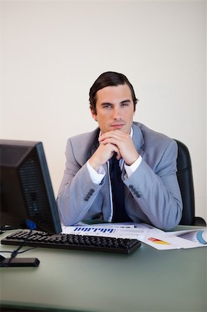 simsearch:400-05748170,k - Businessman in thoughts sitting behind his desk Stock Photo - Budget Royalty-Free & Subscription, Code: 400-05748154