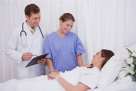 simsearch:400-05748252,k - Medical team talking to bedridden patient Stock Photo - Budget Royalty-Free & Subscription, Code: 400-05748256